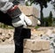 Bauarbeiter trägt Backsteine mit engelbert strauss Narbenleder-Handschuhen